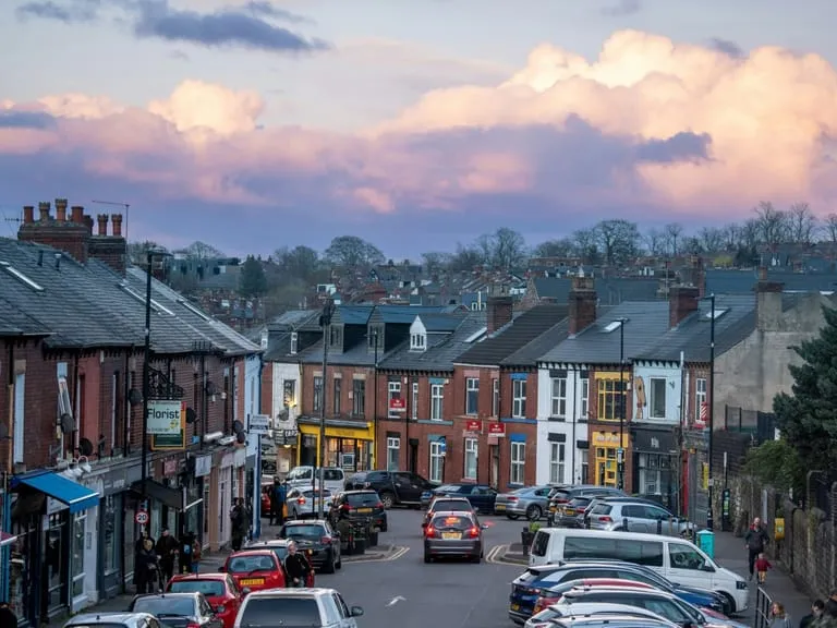 Busy High Street with a lot of parked cars